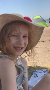 Amber on the beach in a sun hat